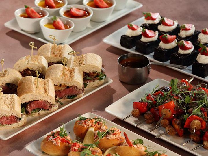 Buffet platters with steak sandwiches, skewers and desserts