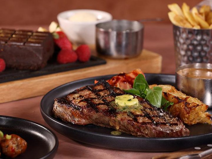 Ribeye steak with sides and a chocolate dessert
